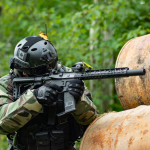 photo of paintball player in Ottawa hiding behind barrels