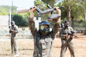 paintball player with their paintball gun overhead surrendering.