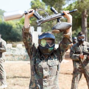 paintball player with their paintball gun overhead surrendering.