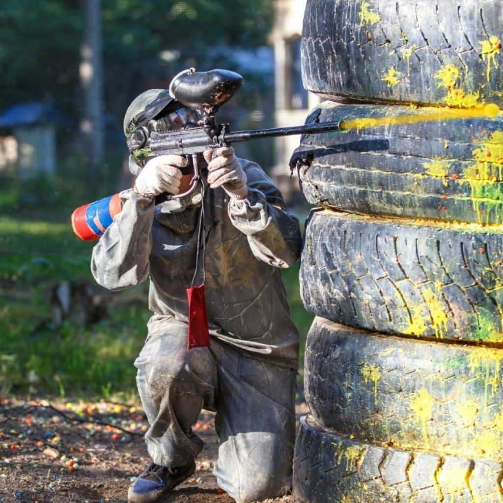 man shooting paintball gun