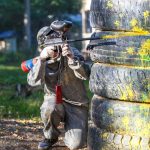 man shooting paintball gun